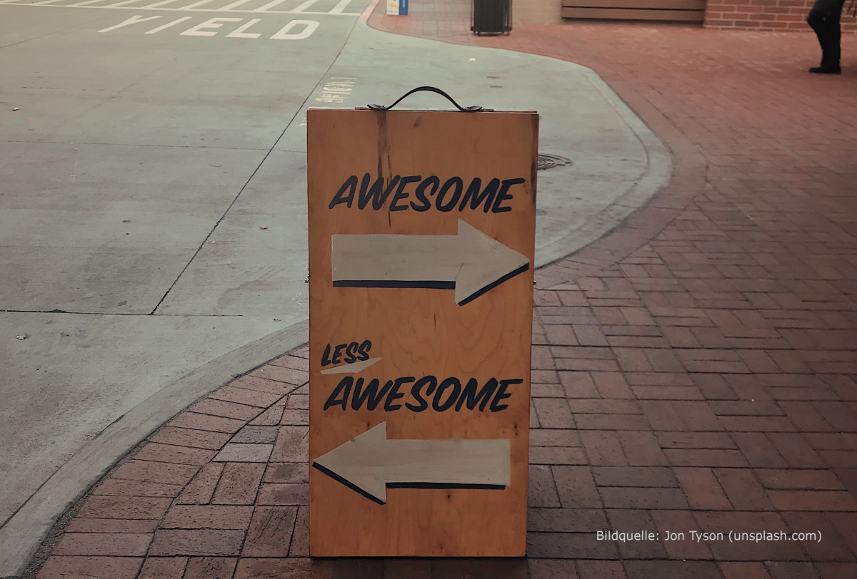Ein Schild auf dem "awesome" mit einem Pfeil nach rechts und "less awesome" mit einem Pfeil nach links steht
